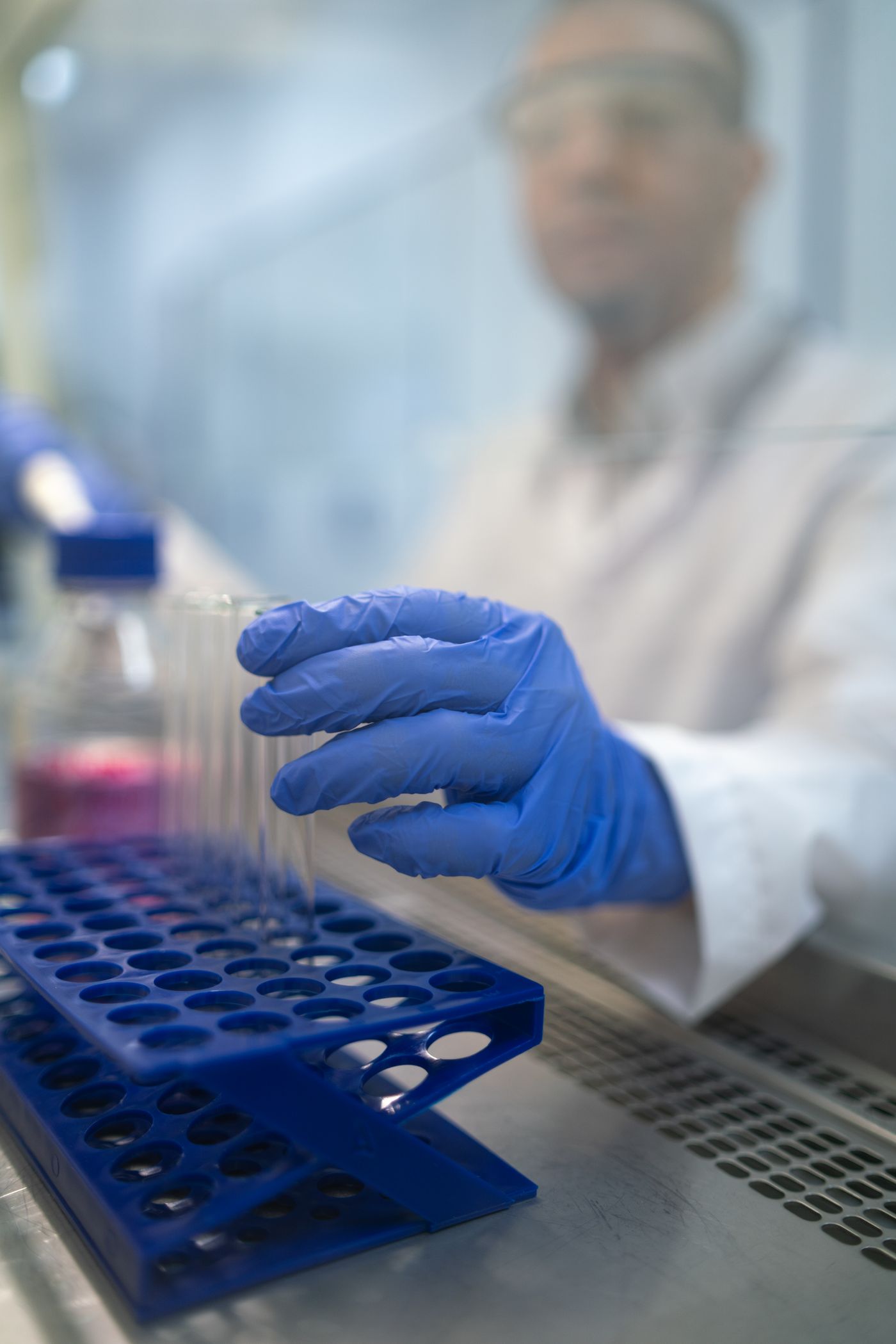 Gloved laboratory professional handling a test tube
